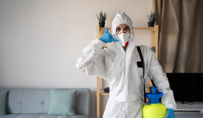 young female exterminator or contractor doing pest control at home doing phone gesture like says...