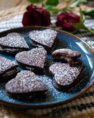 Heart-shaped dark chocolate cookies filled with chocolate and coffee cream. A recipe for lovers on Valentine's Day.