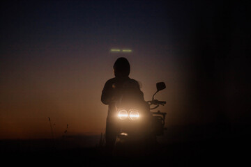 silhouette custom twin headlight retro motorcycle evening sunset and motorcyclist