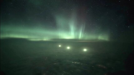 Naklejka premium Aurora borealis over icy terrain, lights in the distance, starry night sky
