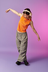 Dancing joyfully under summer lights with headphones on in a playful purple backdrop