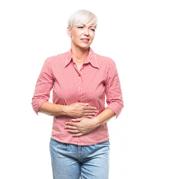 Stomach ache, woman suffering from stomachache, isolated on white background. Ill middle aged woman with chronic gastritis. Abdomen bloating concept.
