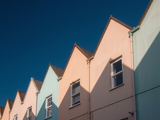 Obraz premium Row of Colorful Townhouses Under Clear Blue Sky, Architectural Facade Detail.