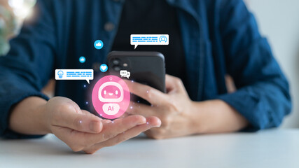 An AI chatbot virtual assistant concept for customer service and digital communication. Hand using a smartphone with a hologram robot icon and online conversation bubbles.