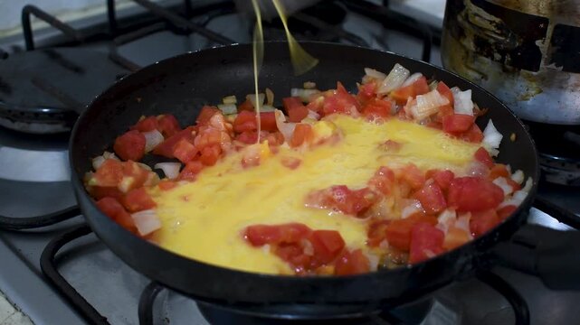 Cooking Colombian Scrambled Eggs, Making Huevos Pericos with Tomato and Onion, Preparing Traditional Scrambled Eggs in Pan. High quality 4k footage