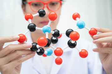Scientist holding molecular model for chemical technology.