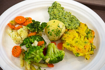 Boiled broccoli with vegetables on a disposable plate. Diet and healthy eating