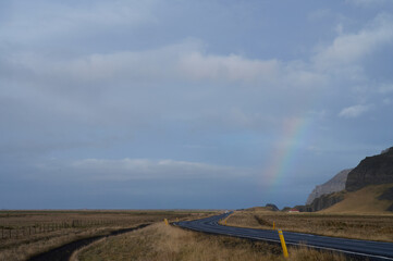road in the mountains of iceland with rainbow