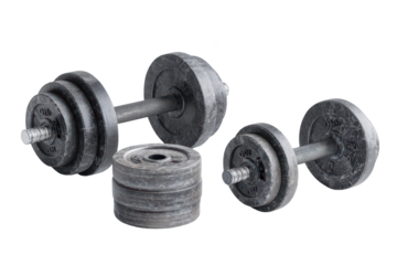 Stacked weights, dumbbell sets on black backdrop, heavy lifting equipment