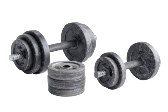 Stacked weights, dumbbell sets on black backdrop, heavy lifting equipment