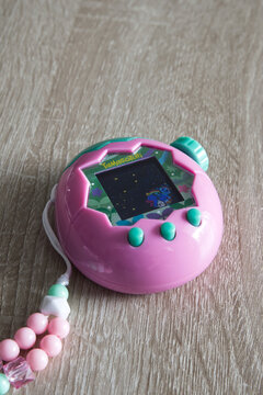 Tamagotchi paradise pink land on wooden background