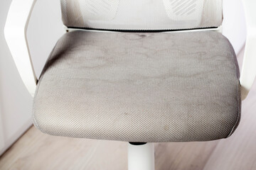Dirty gray upholstery fabric with stains on computer chair before dry cleaning, close-up