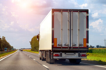 Transportation of consolidated cargo for online stores by trucks with semi-trailers along the highway in the summer. Insurance of cargo and vehicles of transport companies. Copy space for text