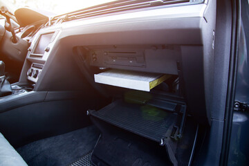 Fototapeta premium Replacement of a modern new anti-allergenic and antibacterial cabin filter in a car, close-up