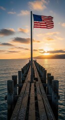 Patriotic pier scene showcases the American flag waving at sunrise vista