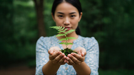 Obraz premium A Woman offering a Small Plant to Another. Sharing Greenery