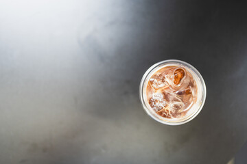 High angle view of iced Americano on black background.