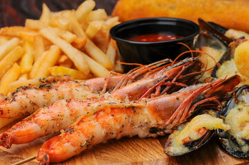 giant shrimps with potatoes on a wooden board macro photo