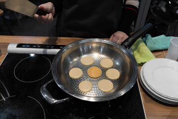 Frying mini pancake cereal in a nonstick frying pan.