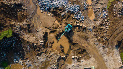 Excavator and dump truck working in rock and sand mine, Construction and mining site view from above.