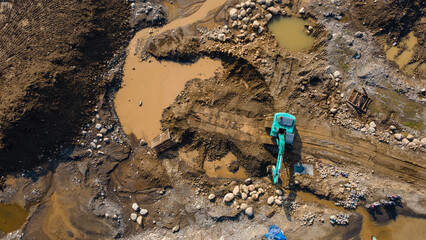Excavator and dump truck working in rock and sand mine, Construction and mining site view from above.