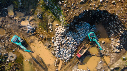 Excavator and dump truck working in rock and sand mine, Construction and mining site view from above.
