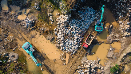 Excavator and dump truck working in rock and sand mine, Construction and mining site view from above.