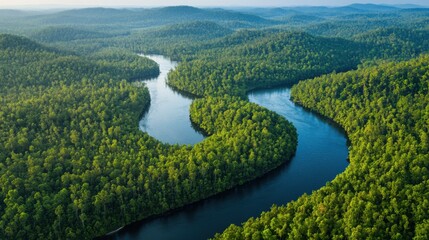 An aerial view of a winding river flowing through a lush green valley, creating a natural and scenic landscape.