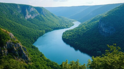 A breathtaking aerial view of a beautiful blue river flowing through a deep canyon, surrounded by a lush green landscape.