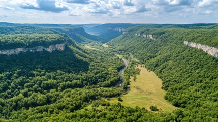 An aerial view of a winding river flowing through a beautiful and scenic landscape with green hills and valleys.