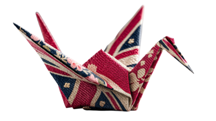 Origami crane folded from a patterned fabric with floral designs, predominantly in red and blue, positioned on a grey surface.