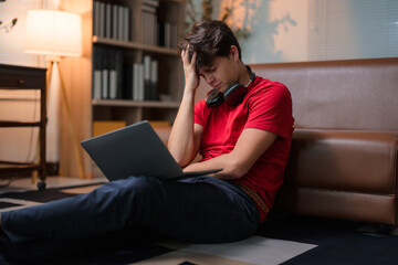 Obraz premium Young man experiencing difficulties with his online education, feeling overwhelmed and stressed