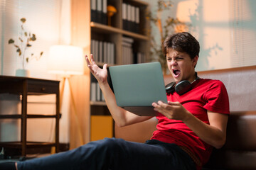 Student struggling with online learning, feeling frustrated and angry while staring at the laptop in the living room, overwhelmed by challenges