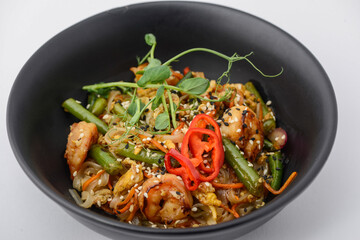 noodles with chicken, microgreens and pepper on a white background