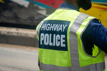 Back view of a highway police officer wearing a reflective vest