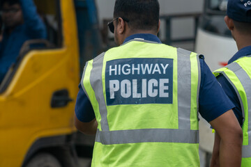 Highway police officer in a reflective vest directing traffic