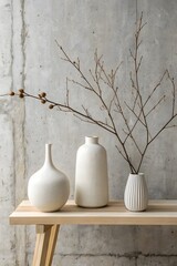 Three Elegant Ceramic Vases with a Dried Branch on a Wooden Shelf