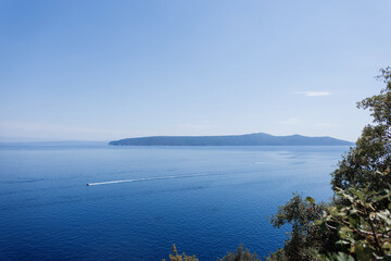 Tranquil view of the Adriatic Sea with calm blue water and minimal clouds on the horizon. Beautiful sea view with blue sky and islands. Summer vacation