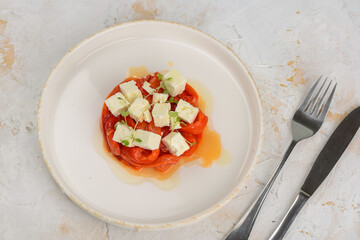 appetizer salad with paprika and cheese in a plate macro on a light background with utensils
