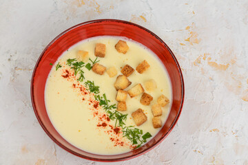 Cream of chicken soup with croutons in a red plate