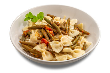 Bow tie pasta with green beans and tomato sauce, garnished with a sprig of mint, on a white plate isolated