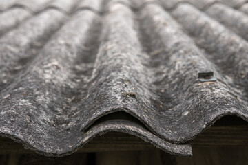 Asbestos removal. Old and very dangerous asbestos roof. Asbestos dust in the environment.