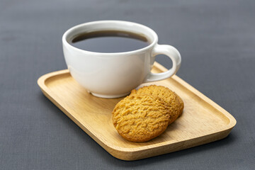 Americano coffee cookie wooden tray white cup hot drink snack breakfast caffeine relaxation cozy delicious treat simple presentation gray background