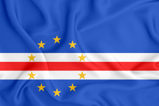 flag of the Republic of Cape Verde with horizontal stripes and ten stars on satin fabric with folds and shadows