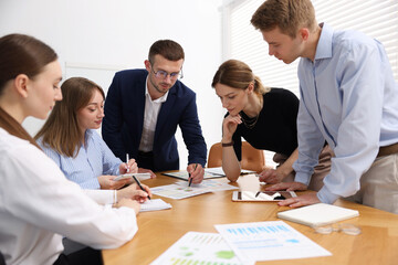 Business coach working with group of people in office