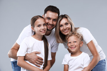 Obraz premium Family portrait of happy parents and their children on grey background