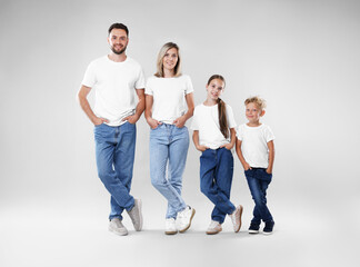 Fototapeta premium Happy parents and their children posing on grey background. Family