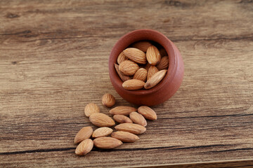 Close up of fresh almonds spilled out of clay pot