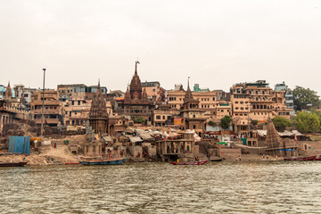 Obraz premium Varanasi cityscape rising from Ganges river with traditional buildings and temples