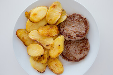 Piatto con hamburger e patate arrosto